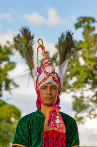 Portrait of bridegroom standing against sky