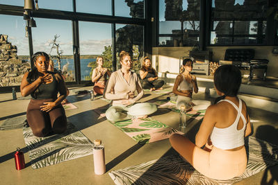 Female coach practicing breathing exercise with women at retreat center