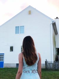 Rear view of woman standing against buildings