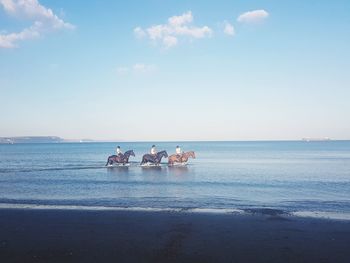 People on beach against sky