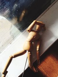 Close-up of wooden doll on window sill