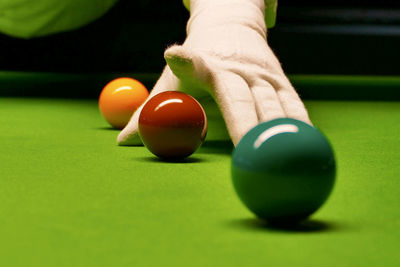 Cropped hand pointing at balls at pool table