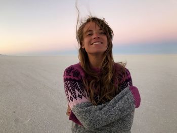 Portrait of smiling young woman at beach during sunset