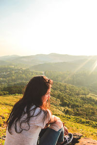 Rear view of man looking at mountains against sky