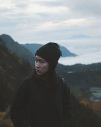 Woman standing on mountain against sky