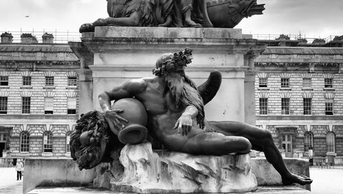 Statue against building in city