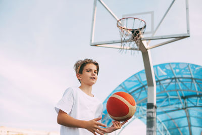 Boy playing with basketball at court