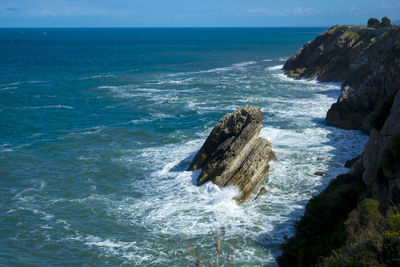 Scenic view of rocks in sea against sky