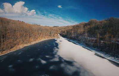 Road amidst snow covered landscape against sky