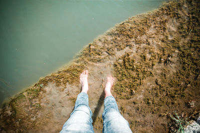 Low section of person on rock by lake