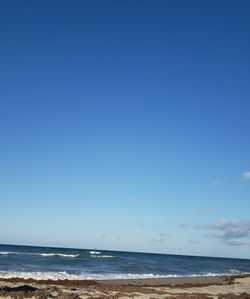 Scenic view of sea against blue sky