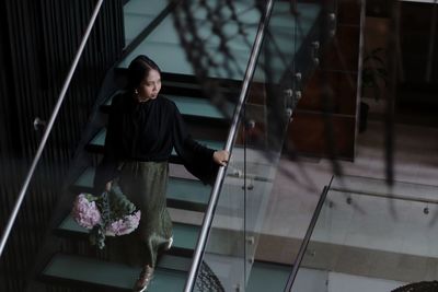 High angle view of young woman moving down on steps