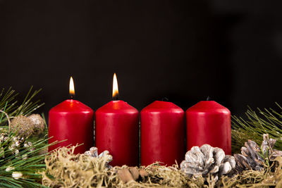 Close-up of illuminated candles against black background