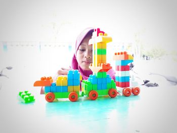 Cute girl playing with toy against white background