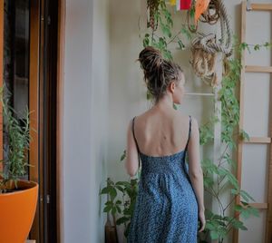 Rear view of man standing against window