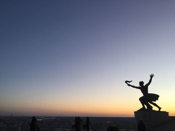 Silhouette of statue at sunset