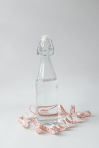 Close-up of glass jar on table against white background