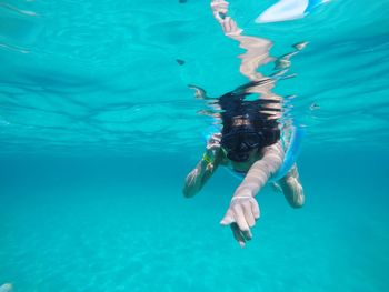 Woman swimming while pointing in sea