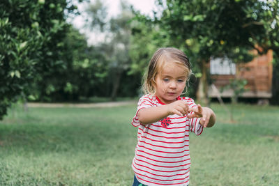 Cute girl standing on grassy land in park