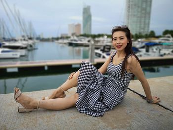 Portrait of smiling woman sitting at harbor