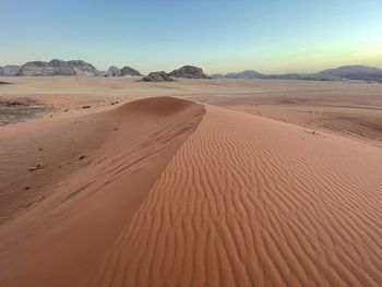 Sand dunes in desert against clear sky