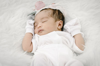 High angle view of cute baby girl sleeping in bed