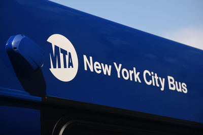 Low angle view of information sign against blue sky