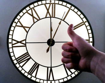 Low angle view of human hand against ceiling