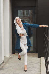 Full length of young woman using mobile phone