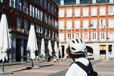 Unidentified female cyclist watching the closed terraces in plaza mayor of madrid during lockdown