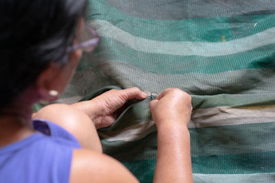 High angle view of woman stitching textile