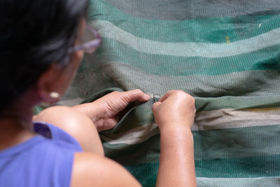 High angle view of woman stitching textile
