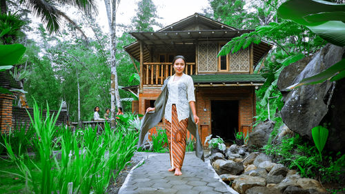 Portrait of woman standing against building