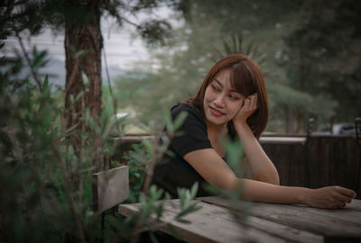 Portrait of young woman sitting on field