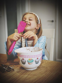 Portrait of a girl holding ice cream at home