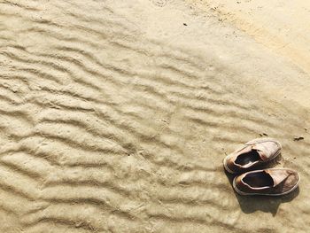 Close-up of shoes on sand