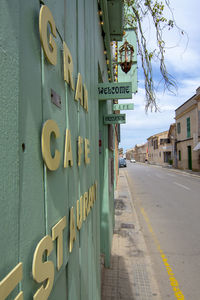 Information sign on road amidst buildings in city