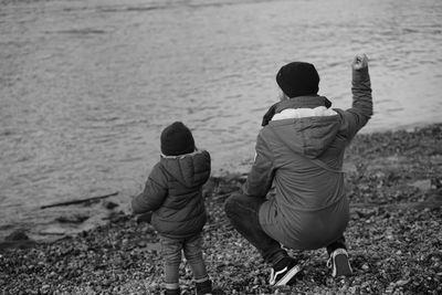 Rear view of couple sitting on beach