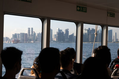 Rear view of people on city buildings by sea