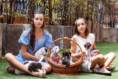 Beautiful young girls having fun with their small french braque puppies