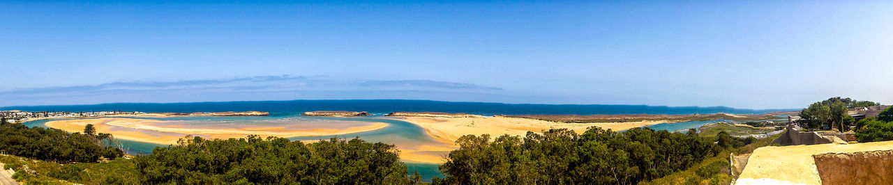 Scenic view of beach against blue sky