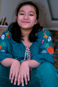 Portrait of smiling young woman sitting at home