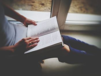 Midsection of woman reading book