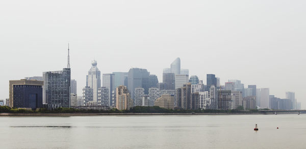 Modern buildings in city against clear sky