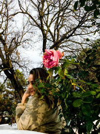 Close-up of young woman holding pink flower tree