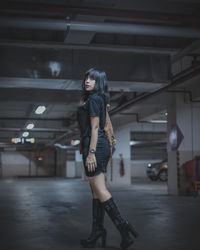 Full length portrait of young woman standing at parking lot