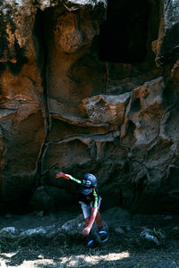 Woman standing on rock in cave