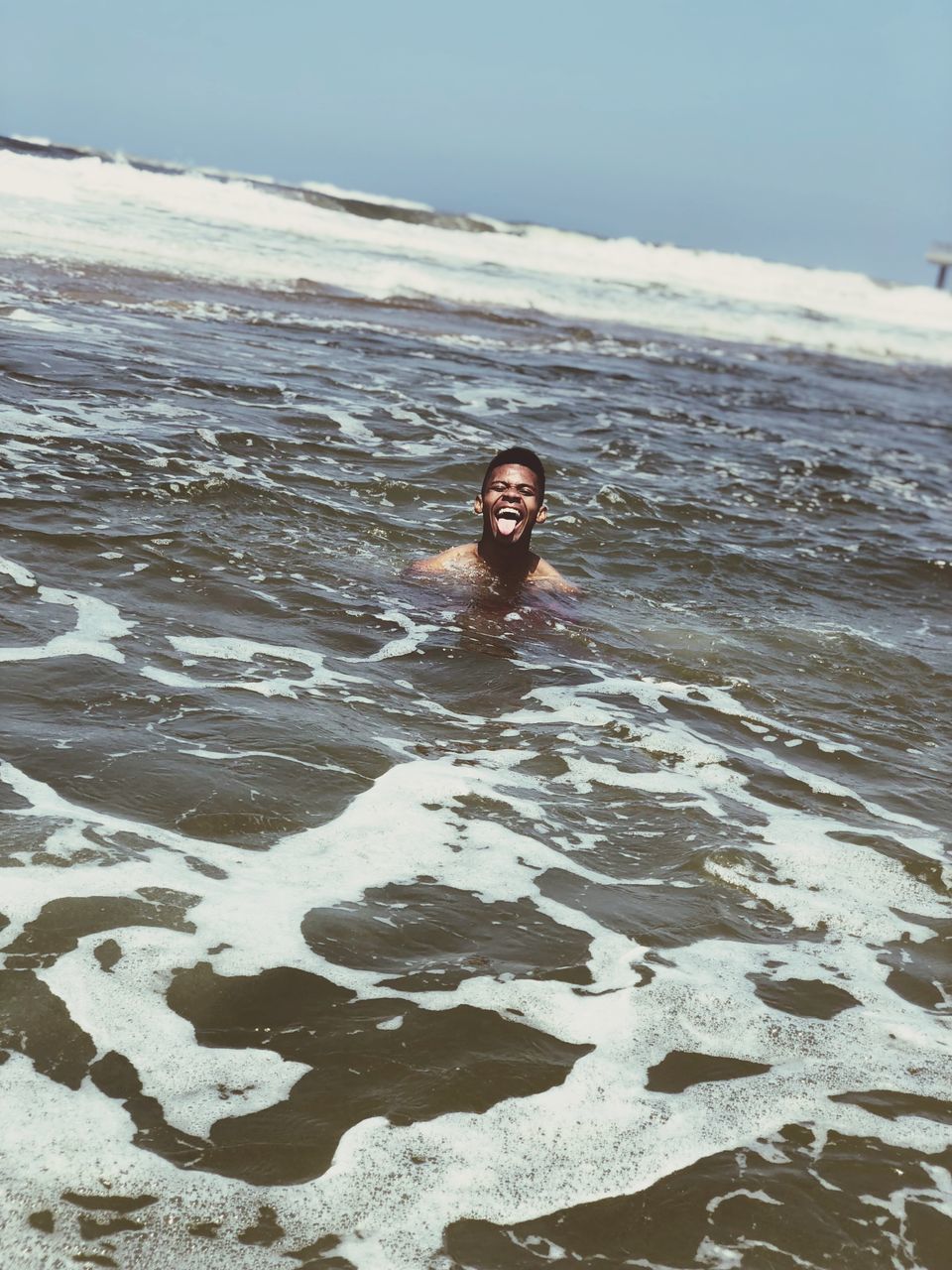 PORTRAIT OF SMILING MAN ON BEACH