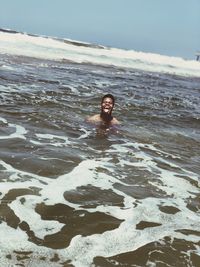 Portrait of smiling man on beach against sky