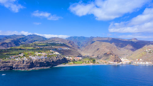 Scenic view of lake and mountains against blue sky